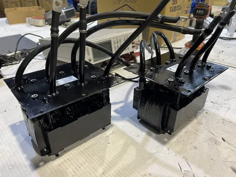 Two large potted transformers or inductors with heavy leads